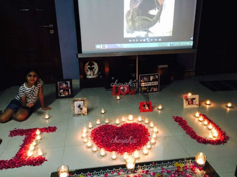 Surprise your partner with a beautiful rose petal decor set up with a movie projector.