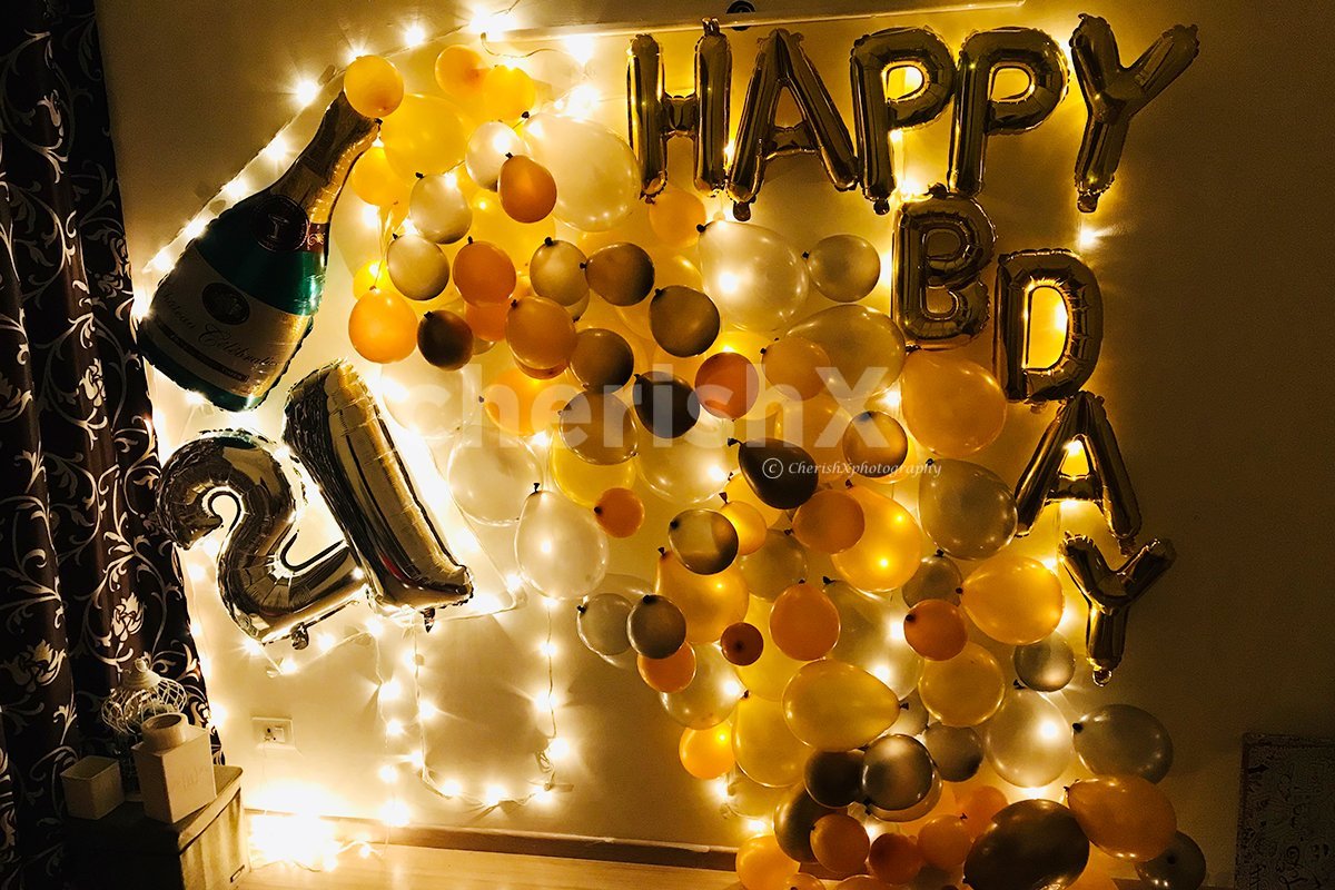 The decor is bright and beautiful with golden and silver balloons and a champagne foil balloon.