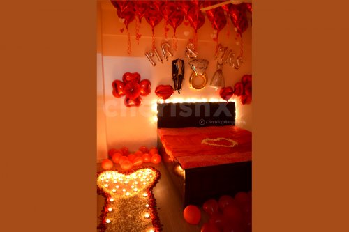 A pathway is created with petals and candles for your partner to reach the room with beautiful decoration.