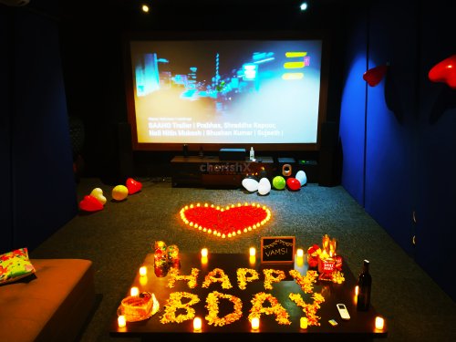 Surprise your special one with this luxurious movie date that consists of candle lights and rose petal decor.