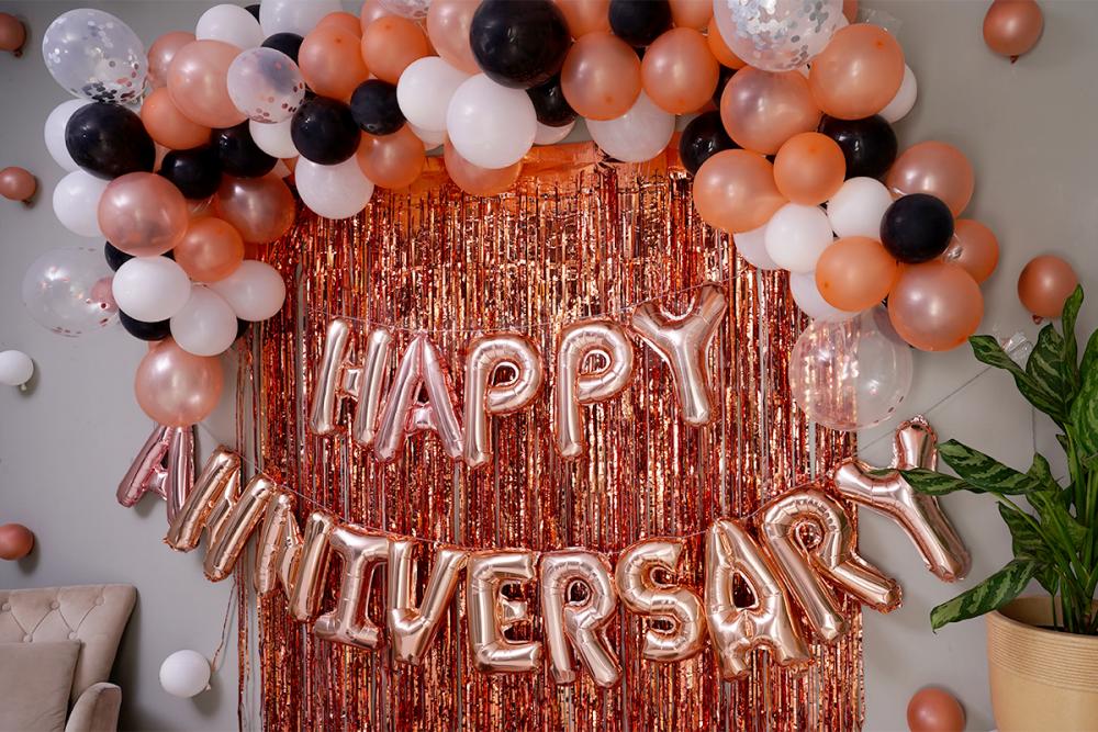 The decor includes "Happy Anniversary" Foil Balloons and bunches of different colored balloons.