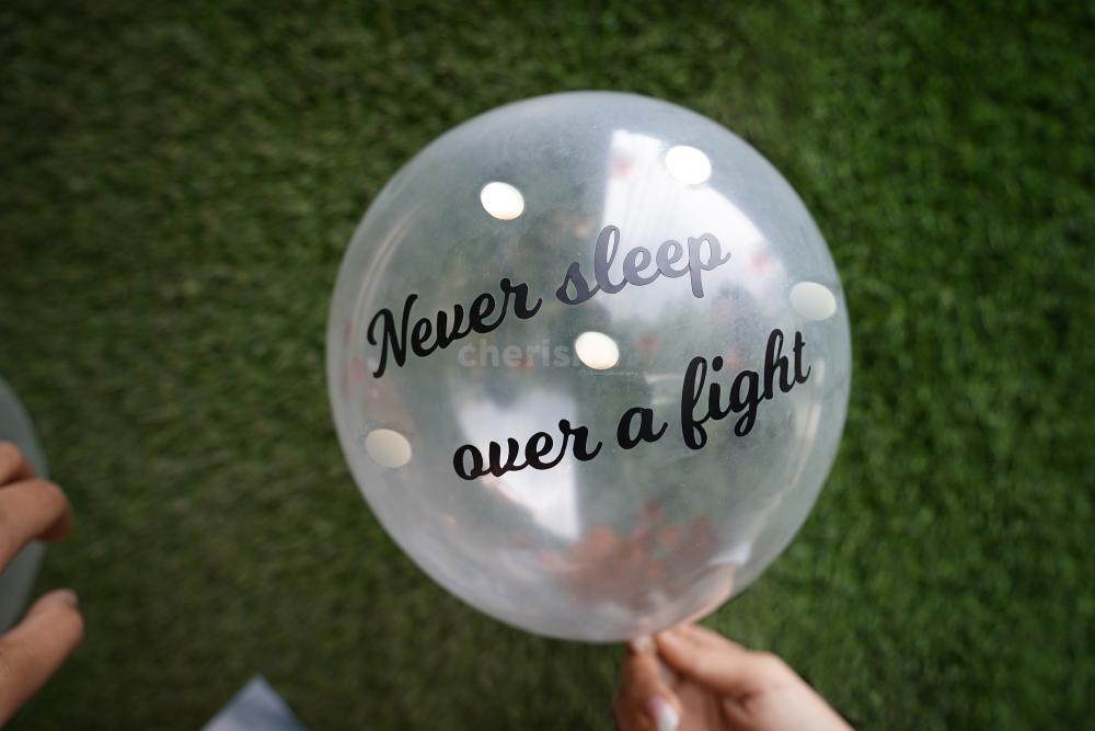 A helium confetti balloon with a 'never sleep over a fight' vinyl message.