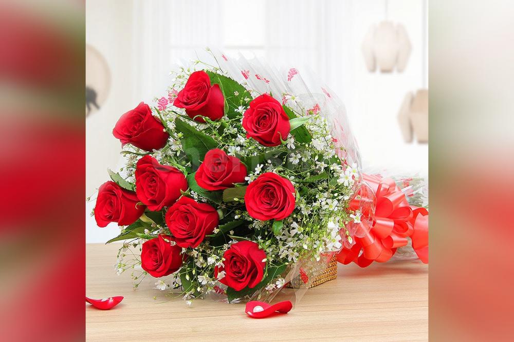 A bouquet of red roses packed with a cellophane sheet.
