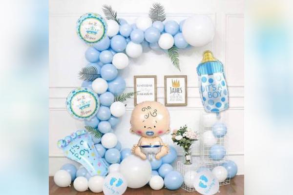 The balloon arch made up of pastel blue and white balloons with a Baby Face & Bottle Foil Balloons