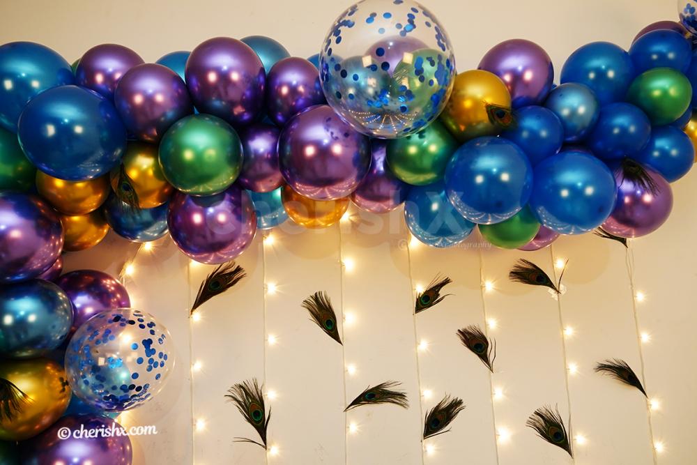 The arc has chrome balloons of color green, blue, purple, golden, and metallic blue to make your Janmashtami celebration attractive.