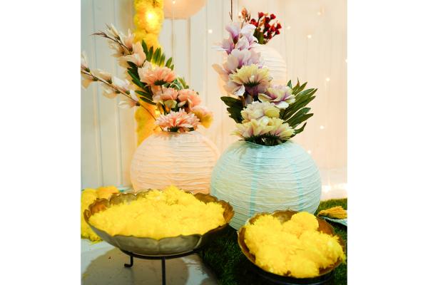 The yellow flower garlands in a rectangle stand are a contrastingly beautiful Mehndi backdrop setup