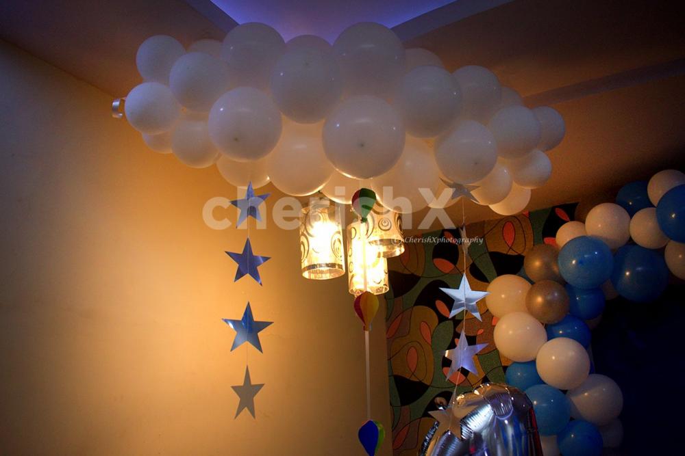 The room decoration includes a wall decorated with an arch of balloons and a parachute made out of balloons to give the look of Disney's "Up" Movie.