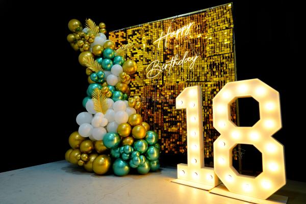 Balloons in shades of gold, silver and peach make for a stunning backdrop for a special 18th birthday celebration.