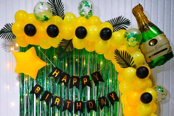 The vibrant yellow balloons and elegant green curtains transform your party ambience.