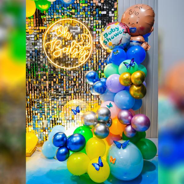 Indulge in the beauty of a rainbow-inspired backdrop, adorned with a burst of balloons in various shades.