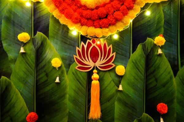 Breathe in the enchanting aroma of green pan strings and celebrate with vibrant orange and yellow garlands.