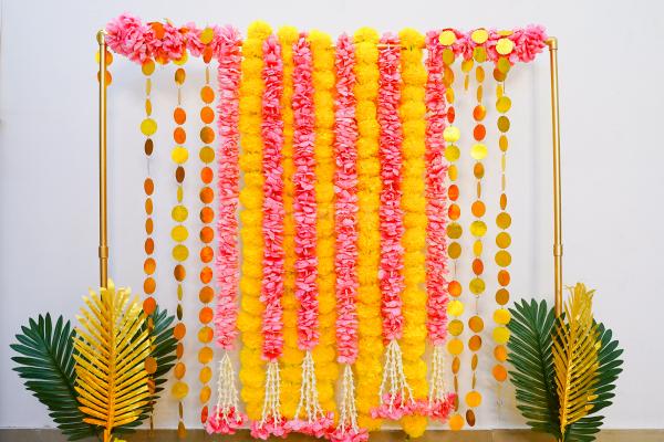Elevate your festive decor game with our all-in-one Royal Garland Diwali Puja Backdrop Kit with a rectangular stand, pink and yellow garlands with tassels, and more.