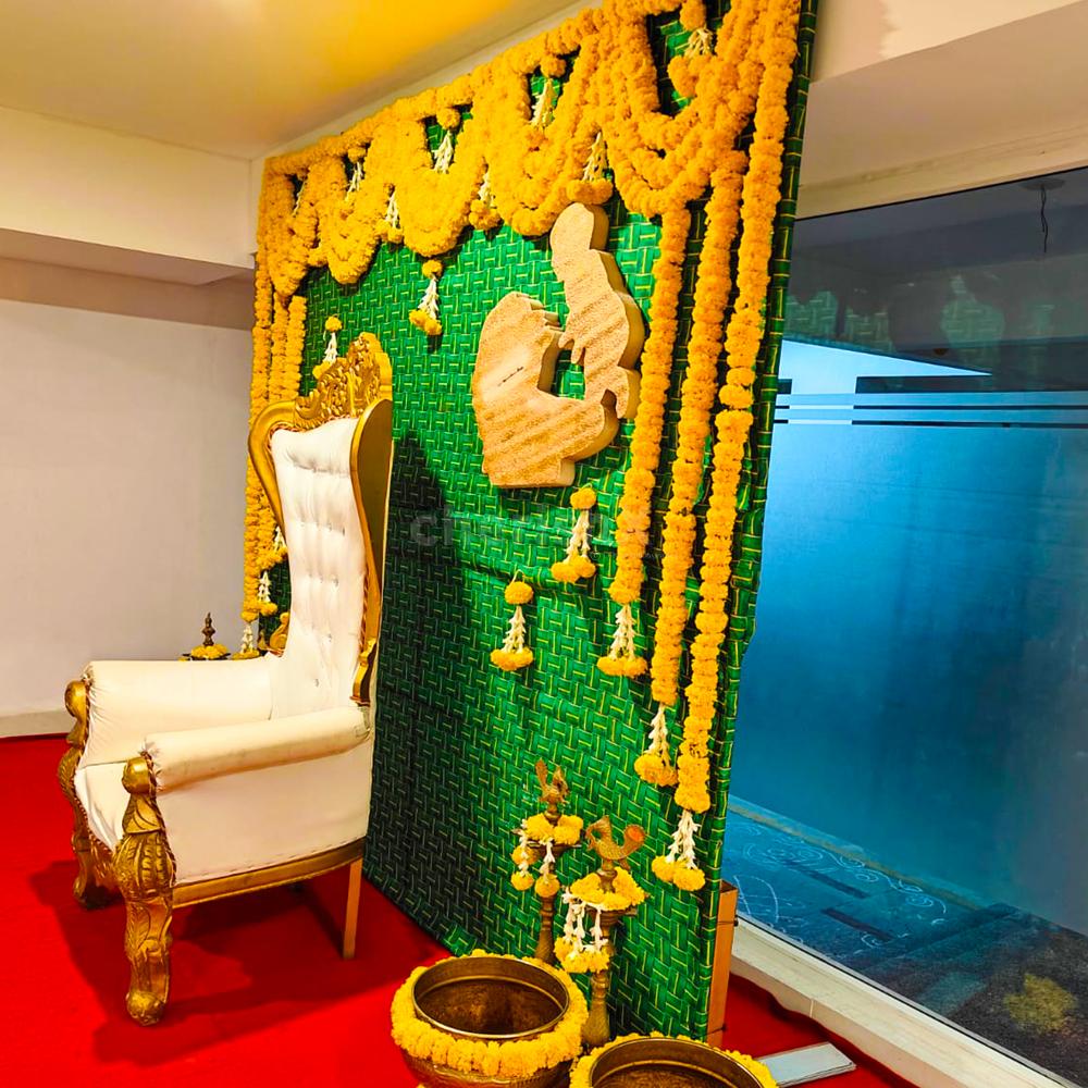 Delicate marigold flowers adorn a Coconut leaf stand backdrop, creating a tranquil ambience for a baby shower celebration.