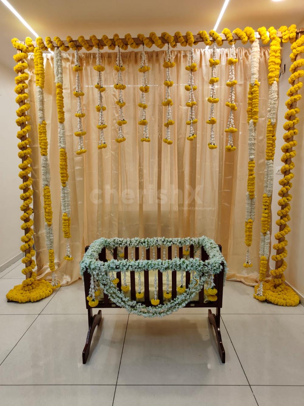 A gold-coloured backdrop adorned with 11 rows of marigold yellow and lily flowers, creates a captivating and visually striking centrepiece.