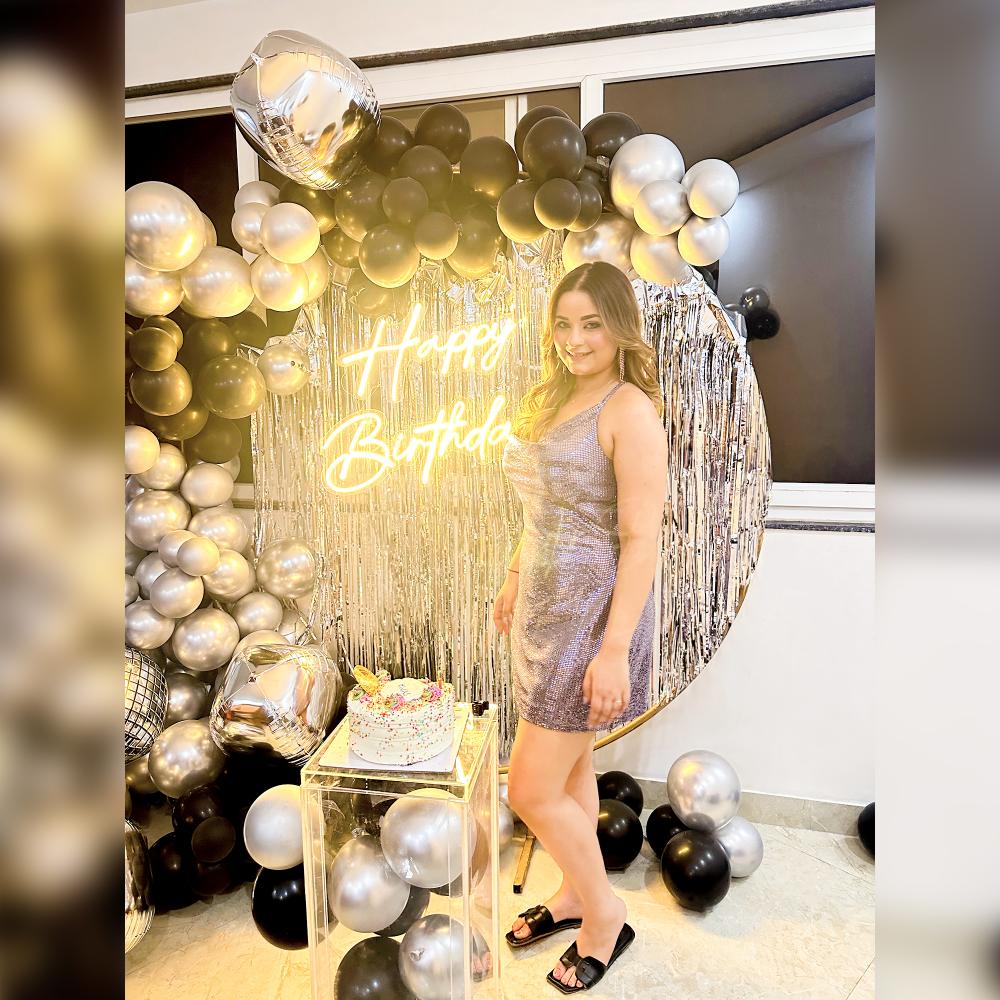Silver Chrome and Metallic Black Balloons elegantly adorn the celebration, complementing the stylish Ring Stand and Happy Birthday Neon Light.