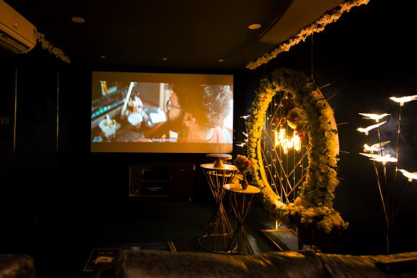 A vibrant movie night experience with family amidst a beautiful ring backdrop draped with artificial flowers