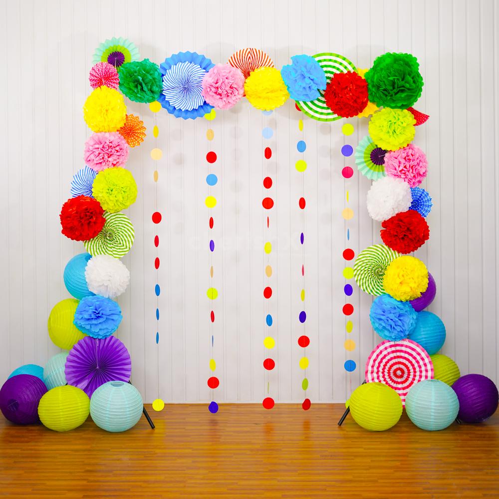 Rosettes, pom-poms, round decor, and lanterns create a vibrant Diwali festivity backdrop.