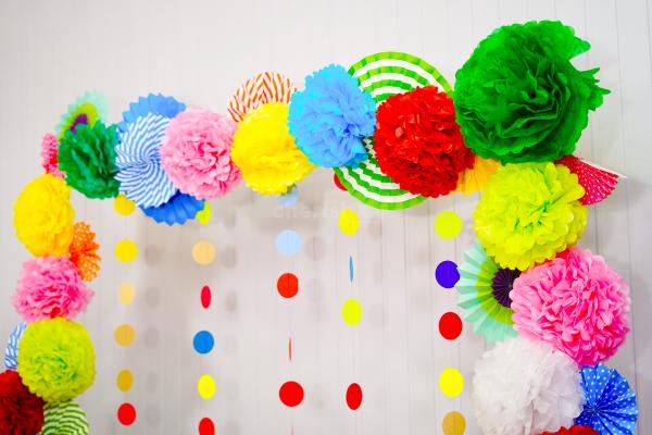 A beautiful arrangement of rosettes, pom-poms, and lanterns for a stunning Dusshera pooja decor.