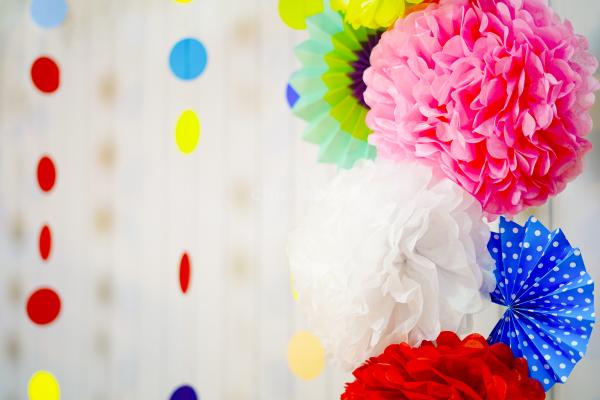 Elegantly set idols against a backdrop of rosettes, pom-poms, and lanterns for celebrations.