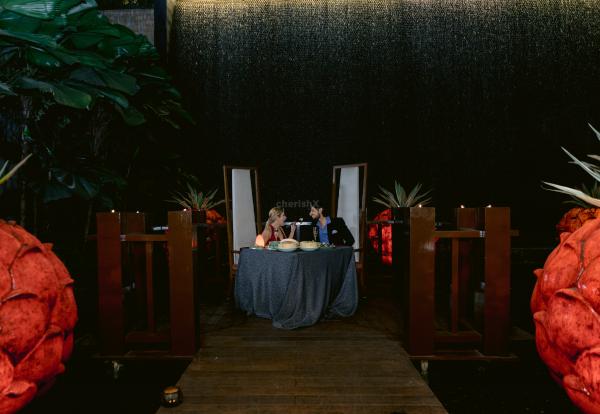 Soak in the enchanting ambiance by the waterfall and a decorated table.