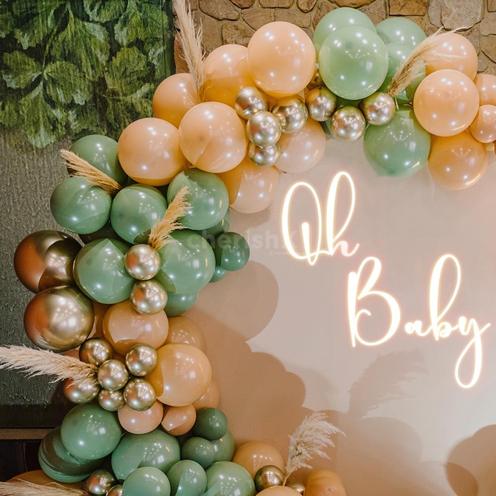 An arch of balloons in retro peach, vintage olive green, and golden chrome hues.