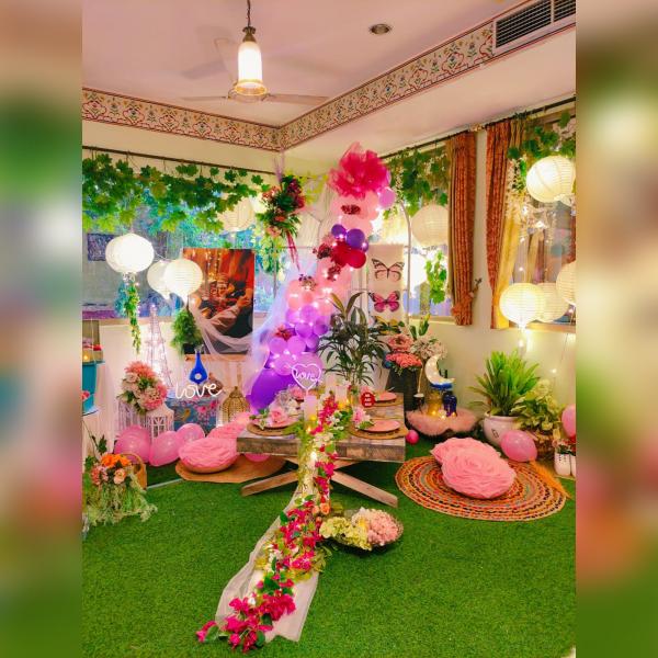 A captivating glimpse of Love Garden's enchanting picnic setup, adorned with dreamy balloon arrangements and a warm love neon sign.