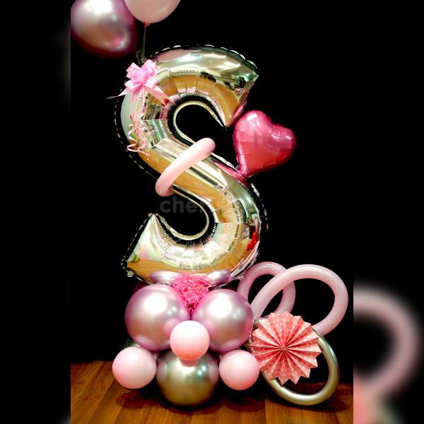 The base is accentuated with an arrangement of beautiful balloons in light pink chrome, pink pastel, and silver chrome