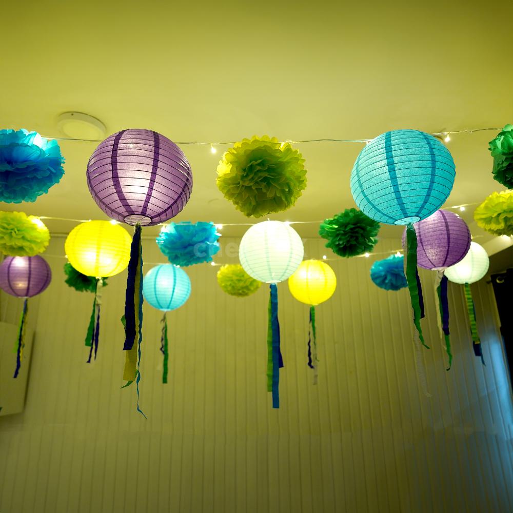 A collection of light green, dark green, and light blue pom poms, part of festive decorations.