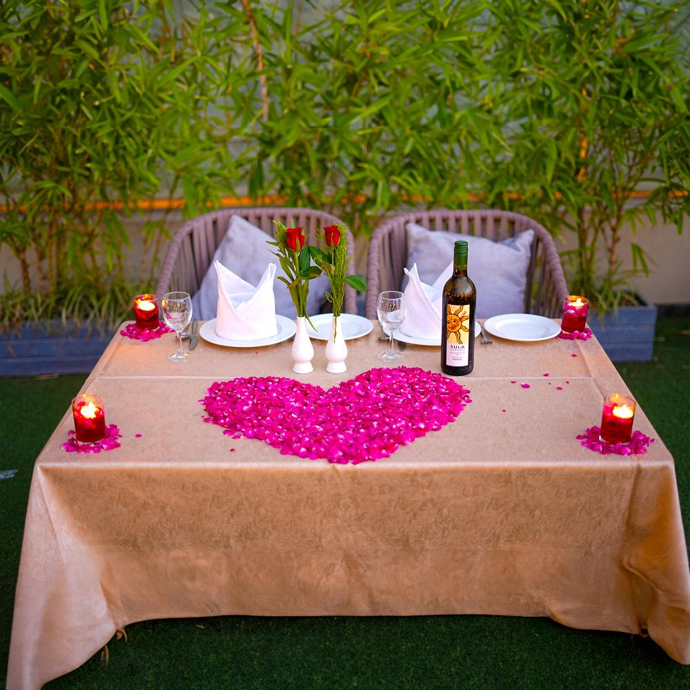 "Romantic setting with rose petals creating an intimate atmosphere at your private table."